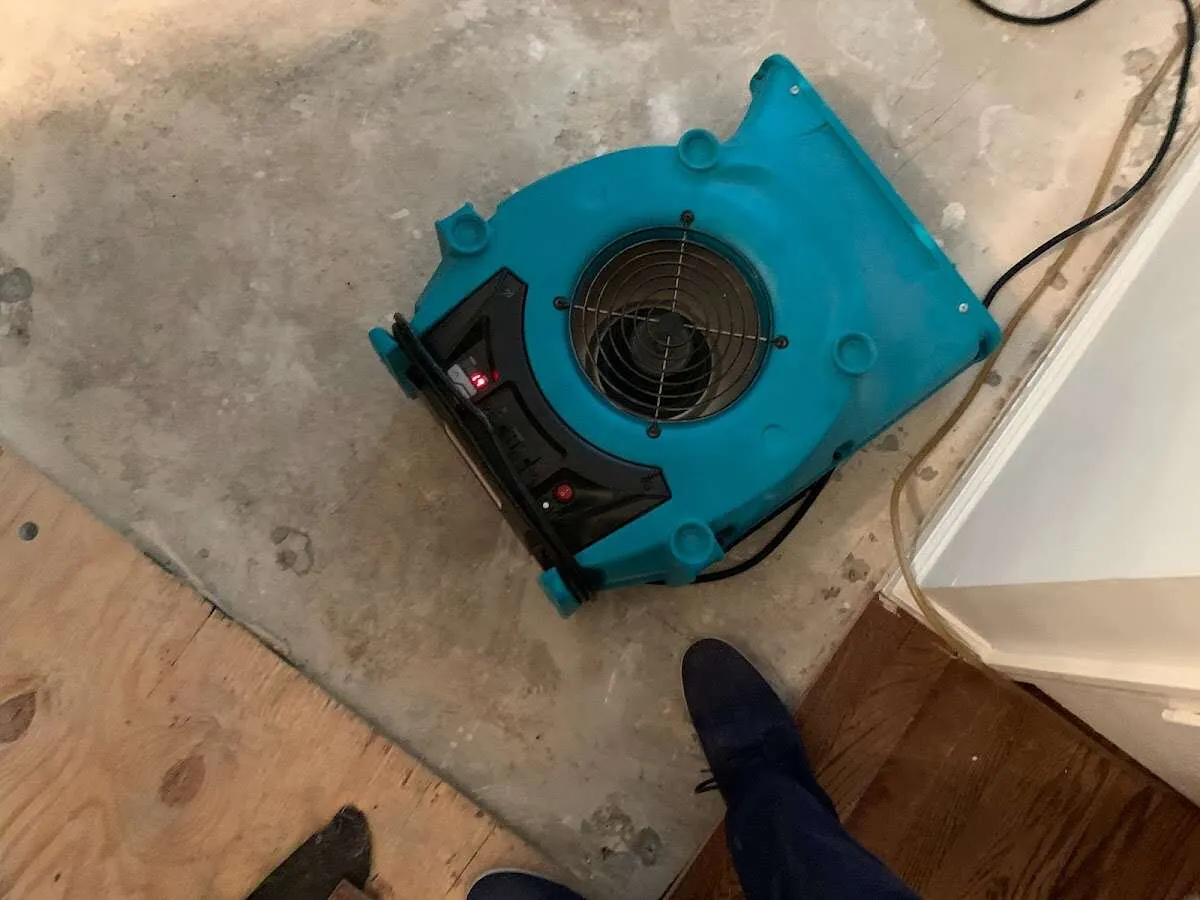 Air mover drying subfloor during Commercial Water Damage Restoration in Vail